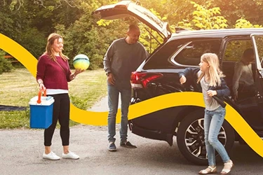 Family Loading Open Boot of Car with Chilly Bin and Ball